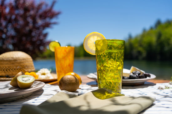 A table setting with Brad Smith's green and yellow pint glasses against a blurry outdoor background
